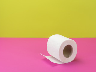 Toilet paper in bright pink and green background.