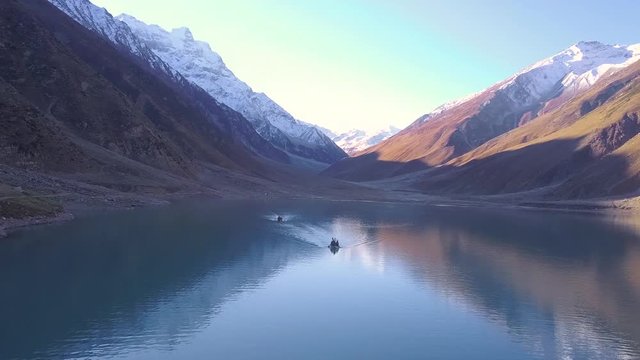 Aerial view of two boats paddling in green coloured lake saiful malook in Naran valley of pakistan