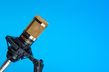  Studio microphone for recording podcasts, songs, and radio programs on a blue background with a place for inscription. copyspace