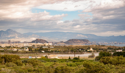 Obraz premium Panoramic view of Alicante, Valencian Community, Spain. Its skyline can be seen perfectly through the dunes and the Mediterranean landscape with the mountains in the background
