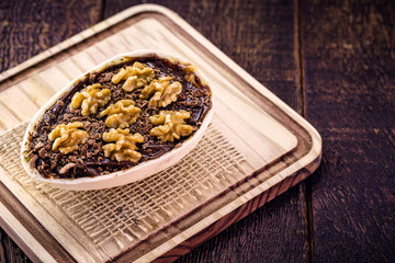 Chocolate egg and walnuts with filling for Easter on wooden background. Brazilian Easter egg, Brazilian tradition.