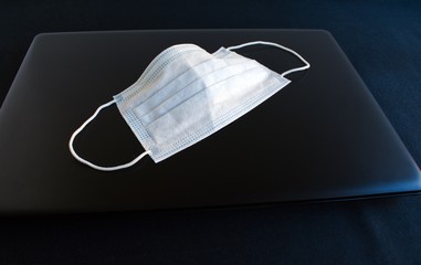 anti-virus mask on laptop for remote work during quarantine