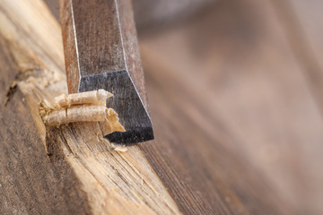 Chisel work in wood and raw wood shavings. Tools and accessories in a carpentry shop.