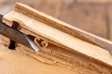 Chisel work in wood and raw wood shavings. Tools and accessories in a carpentry shop.