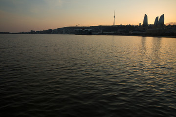 Fototapeta premium Night view of Baku and the seaside of the Caspian sea. Sunset in Baku. Colorful sunset on the Baku boulevard . The seaside of the Caspian sea . Panorama Baku city in he morning, Azerbaijan .