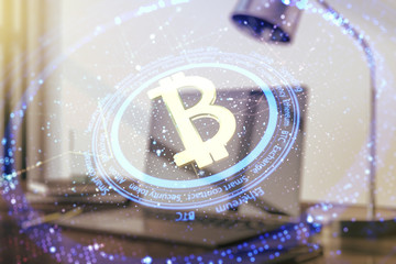 Double exposure of creative Bitcoin symbol with modern laptop on background. Cryptocurrency concept
