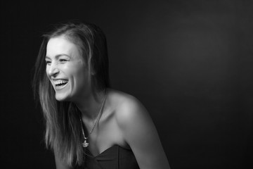 Classic black-and-white dramatic portrait of an adult blonde woman in Studio on black background.