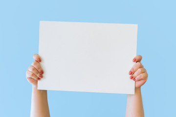 Close up cropped hold in hands blank empty sign white big board for promotional content, pointing...