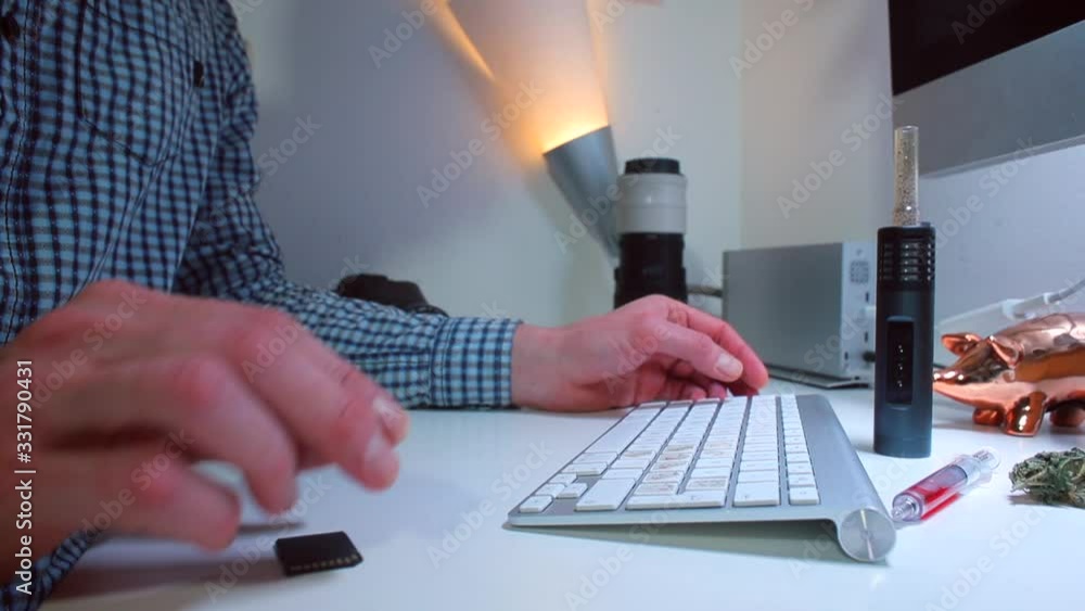 Poster a man sits down at a table in the office and starts typing text on a computer keyboard. workplace co