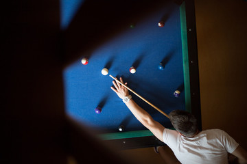 Man plays billiards on a blue table