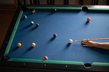 Man plays billiards on a blue table