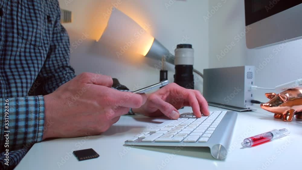 Poster office worker is typing a message on a computer keyboard. the second hand uses a smartphone. digital