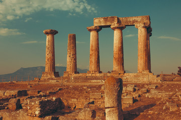 Ruins of Temple of Apollo in Corinth Greece standing up on a hill with remenants of rock walls...