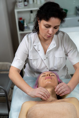 Beautician makes a procedure for a girl to improve facial skin condition