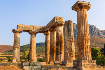 Ruins of Temple of Apollo in Corinth Greece standing up on a hill with remenants of rock walls...