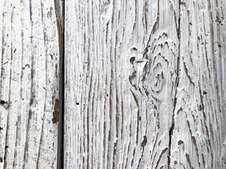 Embossed texture of an old painted wooden board. White board with cracks and scratches. Aged oak surface with a beautiful natural texture. Vertical fibers of a tree. Vintage background in provence
