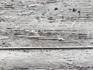 Embossed texture of an old painted wooden board. White board with cracks and scratches. Aged oak surface with a beautiful natural texture. Horizontal fibers of a tree. Vintage background in provence