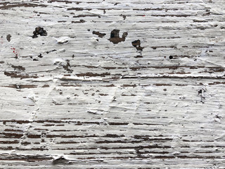 Embossed texture of an old painted wooden board. White board with cracks and scratches. Aged oak surface with a beautiful natural texture. Horizontal fibers of a tree. Vintage background in provence