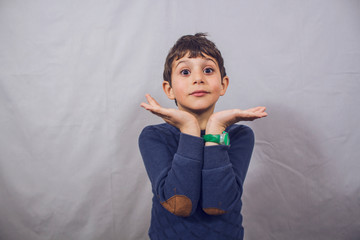 cute boy makes a gesture with his hands