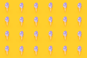 Seamless pattern. Waffle ice cream cone with purple hyacinth flower on yellow background. Spring concept. Copy space, top view