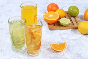 Citrus cider, juice, drink and ingredients on a concrete table. The concept of detox diet and weight loss, natural nutrition, increasing the body's immunity against viruses and colds