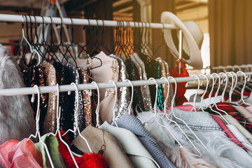 a lot of clothes hangers that are closely located next to each other in a store with women's clothing, an atmosphere of women's space with a large selection of colorful clothes