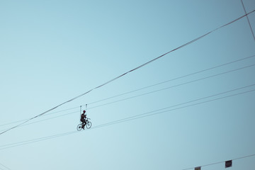 Man balancing on a bicycle on a rope © Hennadii