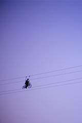 Man balancing on a rope against the sky