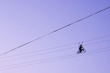 Man balancing on a bicycle on a rope © Hennadii