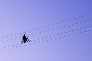 Man balancing on a bicycle on a rope © Hennadii