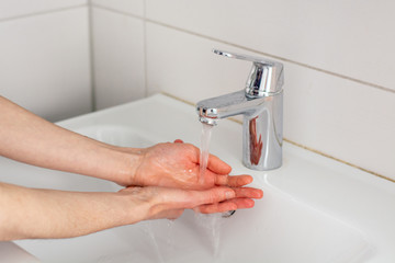 Washing the hands with soap under tap water