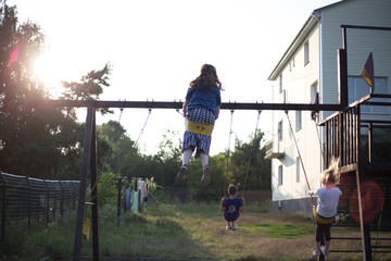 Kids in the backyard swing at sunset