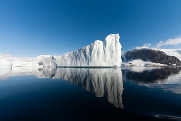 Ice berg reflected in calm water in the Errera Channel in Antarctica