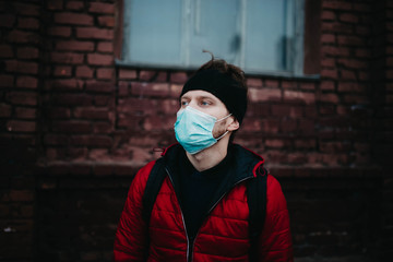 young man in a medical mask in a city during a pandemic.