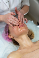 Fototapeta na wymiar Beautician makes a procedure for a girl to improve facial skin condition