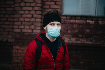 young man in a medical mask in a city during a pandemic.