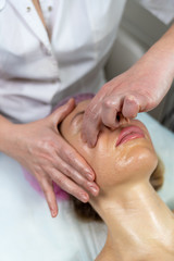 Beautician makes a procedure for a girl to improve facial skin condition