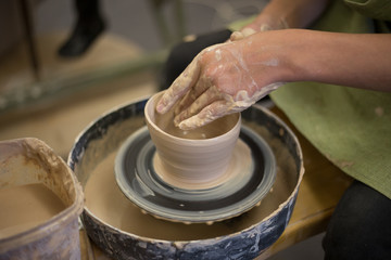 Potter creates a clay jug with his hands