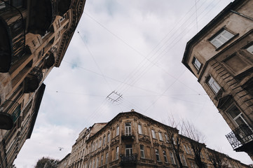 View from below on the facades of old houses standing at the crossroads. Lviv, Ukraine.