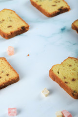 Sliced pie with sultana on the blue marble with turkish delight around
