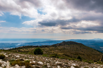 A beautiful view of the Alps mountains range with the French Provence / Cote d'Azur towns and the Mediterranean Sea coastline in the background captured during a hike