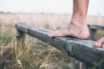 Man barefoot on the log in daylight