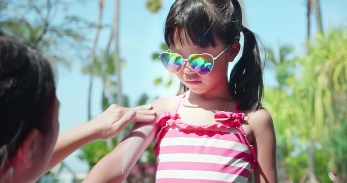 apply sunscreen on girl arm