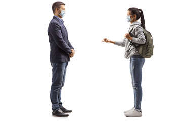 Female student and a young man with medical face masks having a conversation