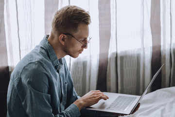 Male freelancer is working with a laptop at home. Remote work concept