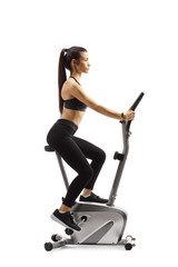 Profile shot of a young woman riding a stationary bike