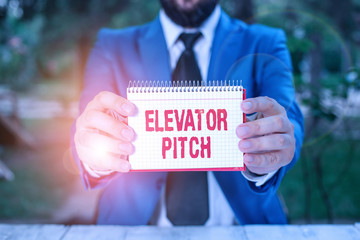 Handwriting text Elevator Pitch. Conceptual photo the elevator statement is a short description of an idea Man holds empty paper with copy space in front of him