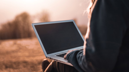 Using laptop computer in nature, technology and freedom concept