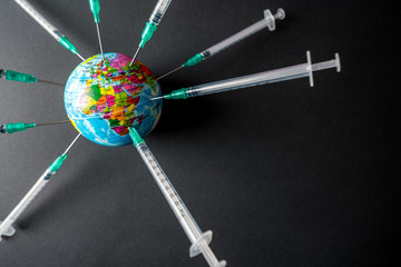 A globe full of syringes. To illustrate the need for vaccine to fight the global pandemic caused by the covid-19 virus.