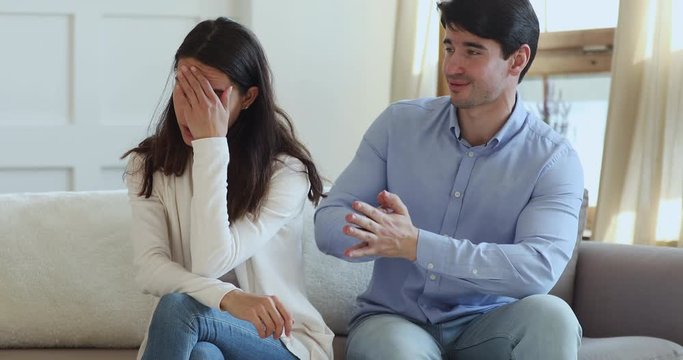Funny boyfriend cheater begging forgiveness concept, apologizing annoyed young girlfriend. Regretful husband feeling guilt and remorse making apology for mistake trying to make peace after conflict.